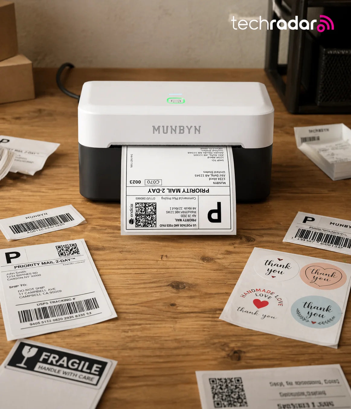 Munbyn 403B label printer on a wooden surface with printed labels around it, featuring the TechRadar logo.
