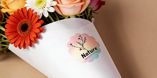 Floral arrangement with a white envelope featuring a 'Nature' label on a beige background