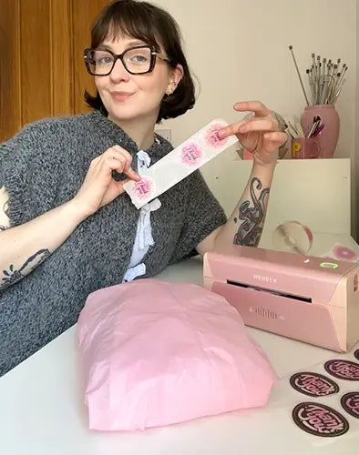 Women holding a pink label with a MUNBYN Thermal Label Printer