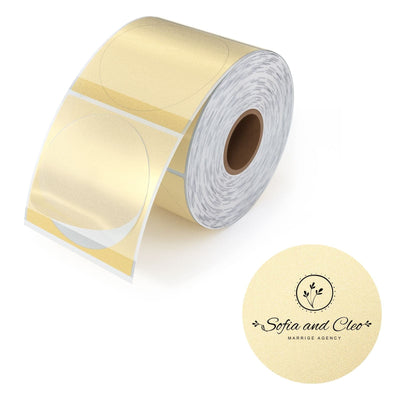 Close-up of 2-inch gold MUNBYN label printer paper sheets with shiny gold labels on white backing paper.
