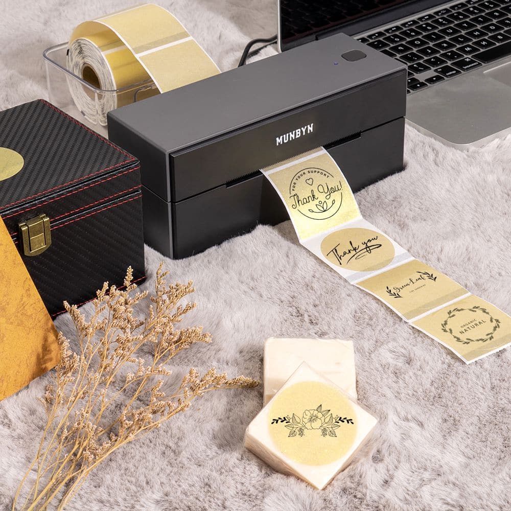 Gold 2-inch label printer paper by MUNBYN, showing shiny gold labels on white backing for use in label printers.